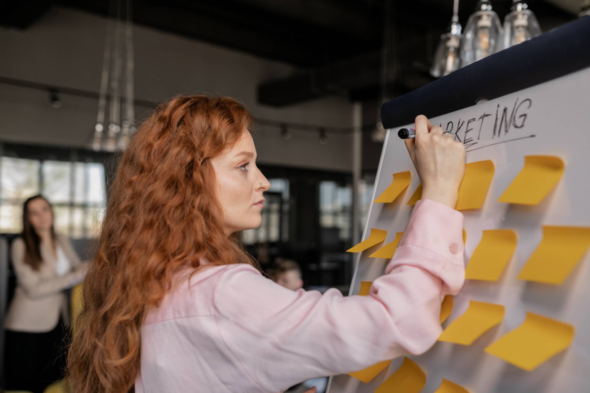 Girl working with Sticky Notes on a white board